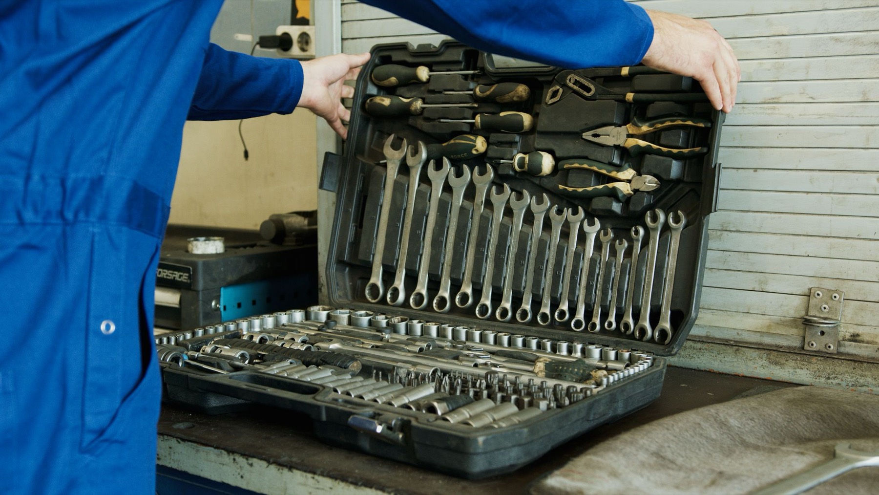 A mechanic's tool case open on a workbench
